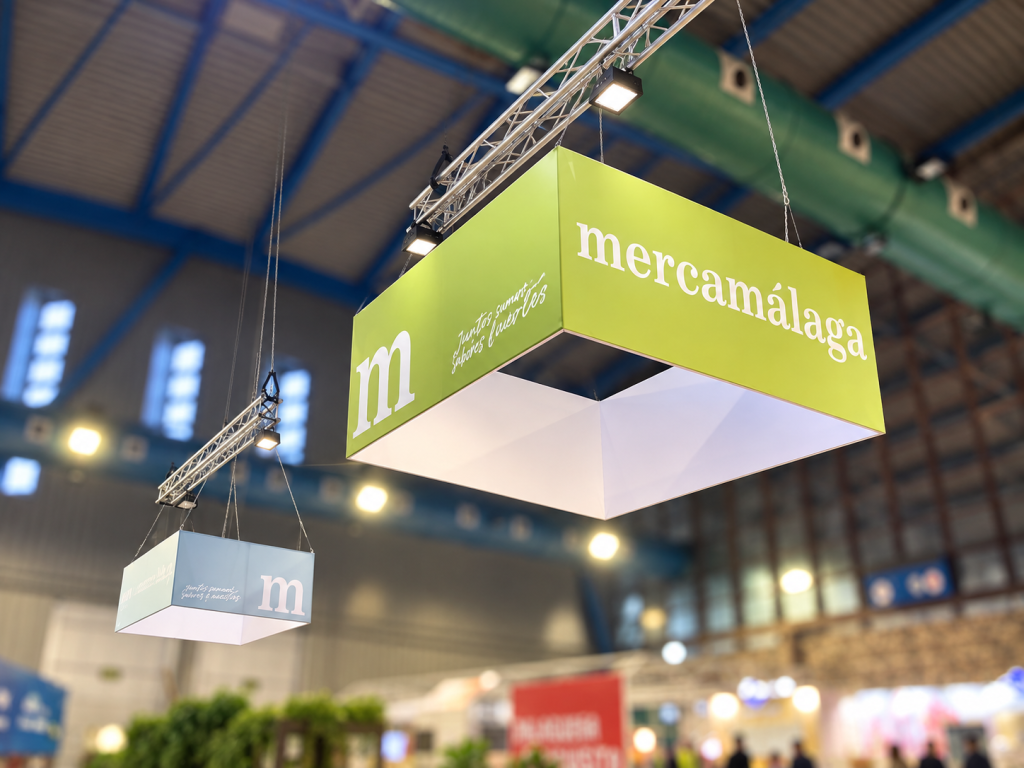 Elemento aéreo con la marca Mercamálaga sobre su stand en la feria H&T de Málaga